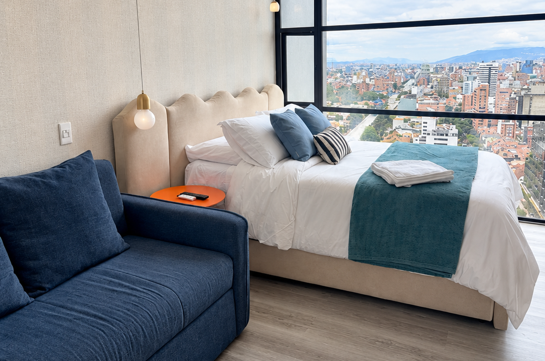 Habitación con sofá y vista a Bogotá - Apartaestudio 33DC